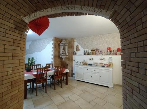 cocina y comedor con mesa y pared de ladrillo en B&B Nonna Assunta, en Collegiove