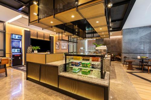 a restaurant with a counter with drinks in it at Chengying Hotel - Sanlitun Taikoo Li in Beijing