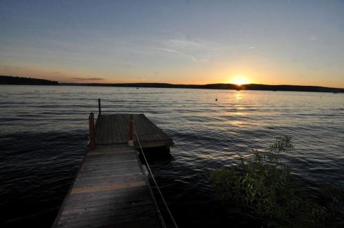 a dock in the middle of a lake at sunset at Lakefront Cabin Rental with Incredible Sunsets on Lake Wallenpaupack, Pennsylvania in Tafton