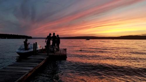 a group of people standing on a dock with a boat at Lakefront Cabin Rental with Incredible Sunsets on Lake Wallenpaupack, Pennsylvania in Tafton