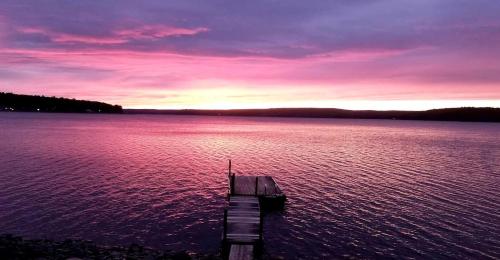 a dock in the middle of a large body of water at Lakefront Cabin Rental with Incredible Sunsets on Lake Wallenpaupack, Pennsylvania in Tafton