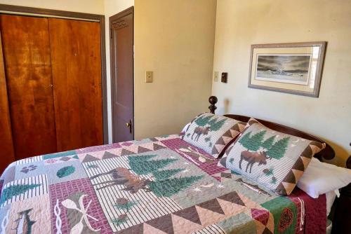 a bedroom with a bed with a quilt on it at Lakefront Cabin Rental with Incredible Sunsets on Lake Wallenpaupack, Pennsylvania in Tafton