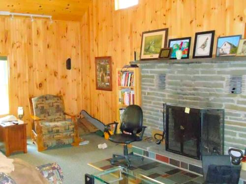 a living room with a fireplace and a television at Peaceful Cabin Rental for Groups on a Farm near Susquehannock State Forest, Pennsylvania in Short Run