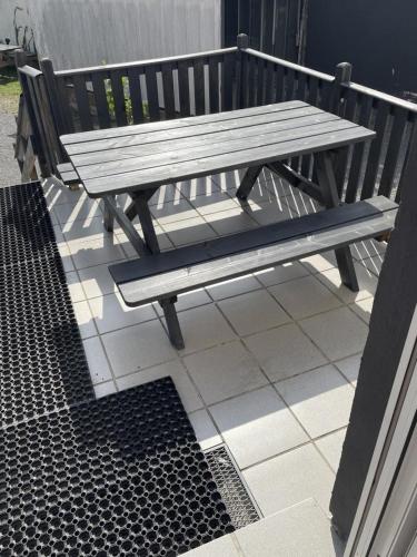 a wooden bench sitting on top of a patio at Schicke Ferienwohnung Philippsburg in Philippsburg