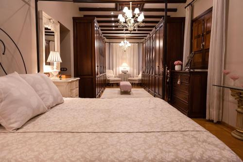 a bedroom with a large bed with a chandelier at Hacienda Los Manchones in Aguilar de la Frontera