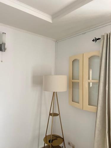 a room with a lamp and a white wall at YEL Home in Libreville
