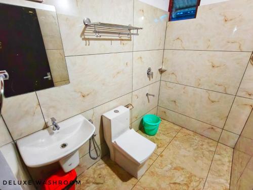 a bathroom with a toilet and a sink at Casa Linda in Devikolam