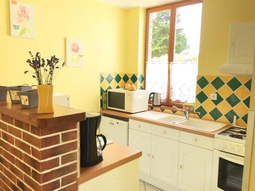 a kitchen with a sink and a microwave at Gîte Margot in Vacqueriette