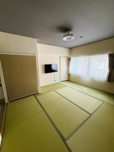 an empty room with a door and a window at 福の荘 美野島 in Fukuoka