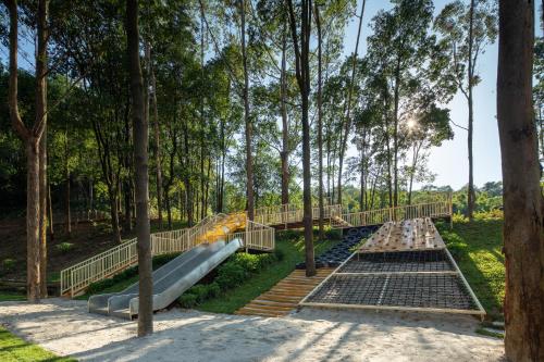 a slide in a park with trees at Trip.com Group Country Retreats(Guangzhou Bella vita manor) in Huadong