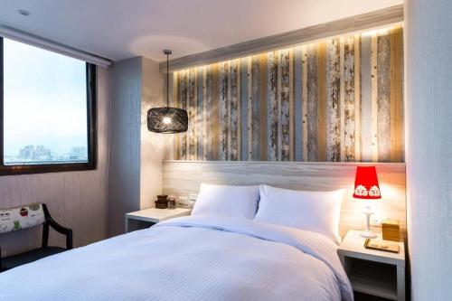 a bedroom with a large white bed and a window at 樂亞亞奇文旅 in Luodong