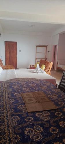 a bedroom with two beds and a blue blanket at Adisham village home in Haputale
