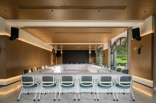 a conference room with a large white table and chairs at Trip.com Group Country Retreats(Guangzhou Bella vita manor) in Huadong