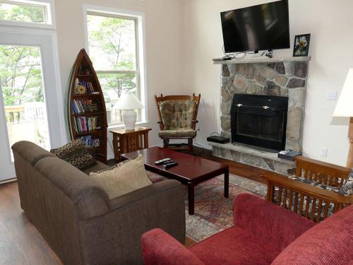 a living room with a couch and a fireplace at Lakefront Vacation Rental with Superb Views over Lake Wallenpaupack in Hawley, Pennsylvania in Tafton