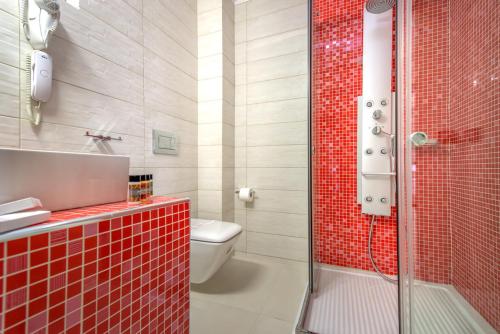a bathroom with a red tiled shower and a toilet at Koukounaria Hotel & Suites in Alykes