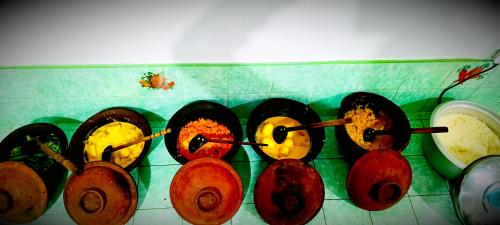 a row of pots on a counter with spatulas at Adisham village home in Haputale