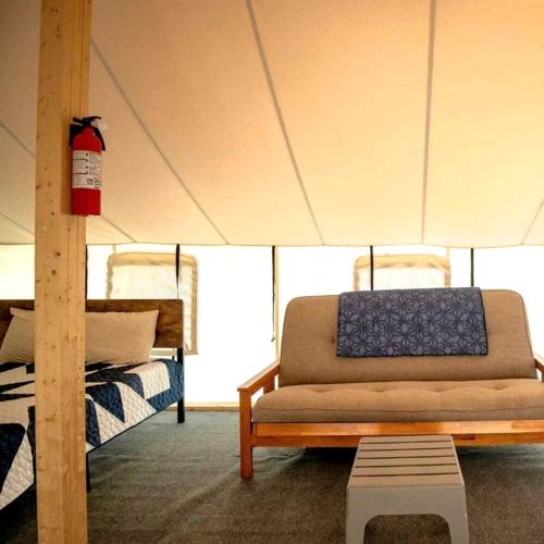 a living room with a couch in a tent at Charming Tented Cabin Placed in a Selcuded Area in Logan, Ohio in Logan