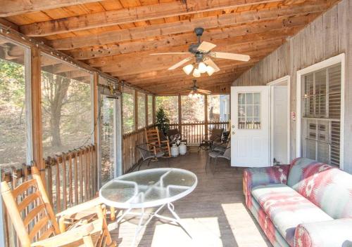 a screened in porch with a couch and a ceiling fan at Delightful Vacation Rental for Group Getaway in Polk County, Tennessee in Reliance