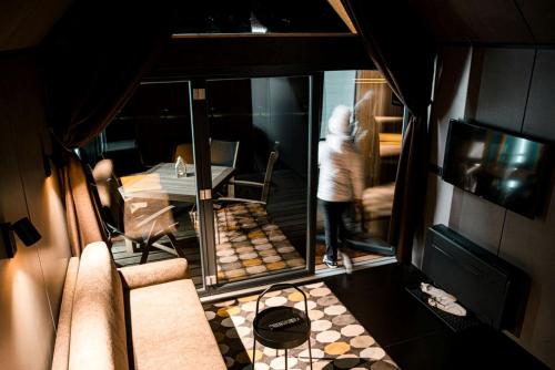 a person is standing in a room with a mirror at Luxurious Cabin Rental with a Hot Tub near Maribor for Glamping in Slovenia in Brestrnica