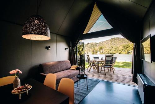 a living room with a couch and a table at Luxurious Cabin Rental with a Hot Tub near Maribor for Glamping in Slovenia in Brestrnica
