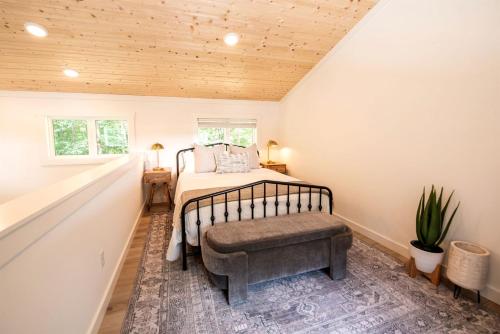 a bedroom with a bed with a bench in it at Stunning and Fully-Equipped Tiny House with Breathtaking Views of South Cumberland State Park in Monteagle, TN in Monteagle