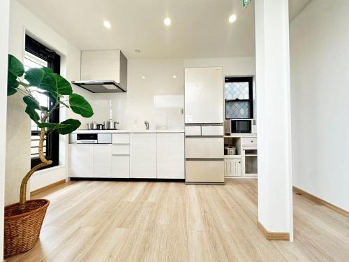 a kitchen with white cabinets and a potted plant at Mulan Stay 松尾大社 in Kyoto