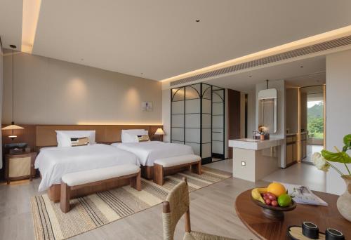 a hotel room with two beds and a table at Trip.com Group Country Retreats(Guangzhou Bella vita manor) in Huadong