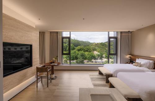 a hotel room with two beds and a large window at Trip.com Group Country Retreats(Guangzhou Bella vita manor) in Huadong