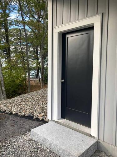 a black door on the side of a house at Lake Cabin Ideal for Outdoor Adventures in Maine in North Harpswell