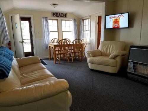 a living room with two couches and a table at Charming Vacation Cabin with Waterfront Views on Pine Lake, Michigan in Wellston