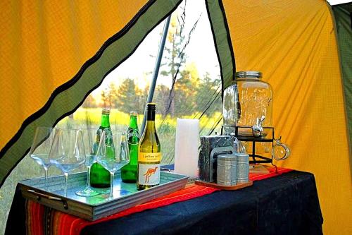ein Tisch mit Weinflaschen und Gläsern darauf in der Unterkunft Grand Canyon Glamping Tents Perfect for Arizona Vacations in Tusayan
