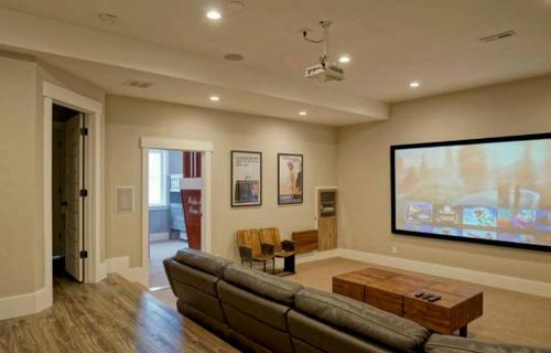 a living room with a couch and a large screen at Luxurious Pet-Friendly Vacation Rental close to Mirror Lake in Kamas, Utah in Kamas
