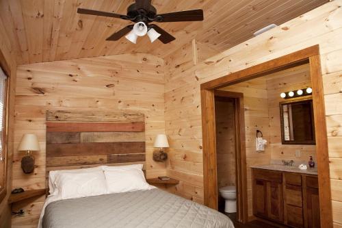 Un dormitorio con una cama y un ventilador de techo. en Beautiful Cabin with Hot-tub in Herod, Illinois, en Karbers Ridge