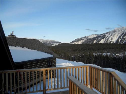 ein Balkon mit Blick auf einen schneebedeckten Berg in der Unterkunft Deluxe Getaway Rental in a Mountain Cabin near Lake McDonald, Montana in West Glacier