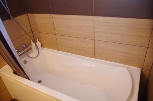 a white bath tub in a bathroom with wooden walls at Fjord Guesthouse in Súðavík