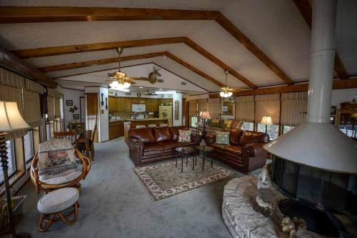 un soggiorno con mobili in pelle e un camino di Riverfront Cabin with Spacious Interior, Large Deck and Views in Texas a Wimberley