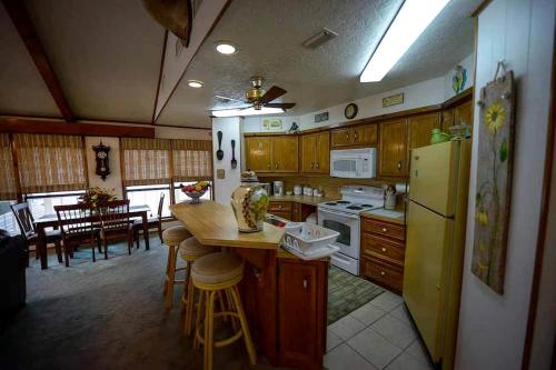 una cucina con frigorifero, tavolo e sedie di Riverfront Cabin with Spacious Interior, Large Deck and Views in Texas a Wimberley