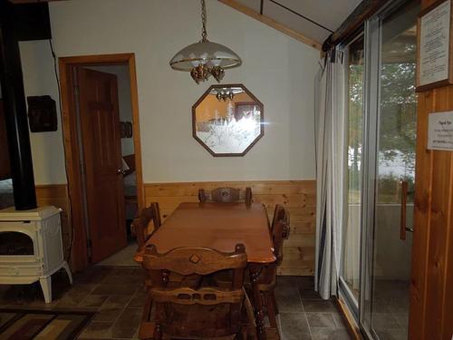 a dining room with a wooden table and a chandelier at Lakeside Cabin Rental with a Boat Dock in Pine River, Minnesota in Pine River