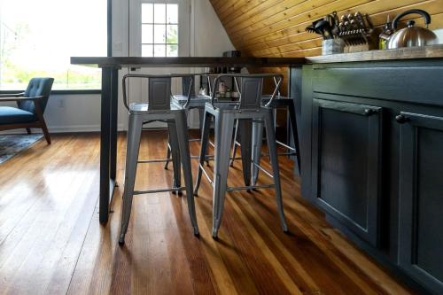 a kitchen with two bar stools at a counter at Beautiful A-frame with Hot-tub in Makanda, Illinois in Goreville