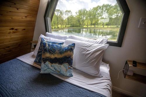 a bed with pillows in a room with a window at Beautiful A-frame with Hot-tub in Makanda, Illinois in Goreville