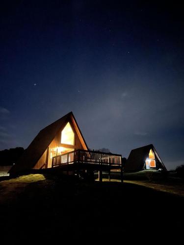 a couple of small wooden houses at night at Beautiful A-frame with Hot-tub in Makanda, Illinois in Goreville
