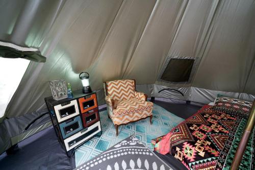 a room with a tent with a chair and a table at Off-Grid Creekside Tent Ideal for a Glamping Experience in Cosby, Tennessee in Cosby