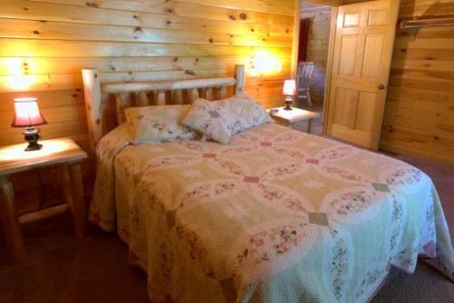 a bedroom with a bed in a log cabin at Romantic Forest Cabin Getaway near Cantwell Cliffs in Logan, Ohio in Cedar Grove