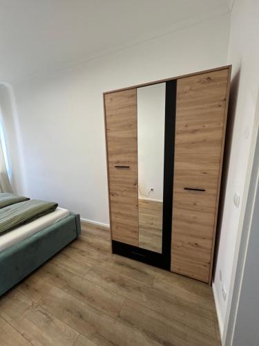 a bedroom with a wooden dresser with a mirror at Sofia Apartment Neubaugasse 1 Nähe Redbull Ring in Knittelfeld