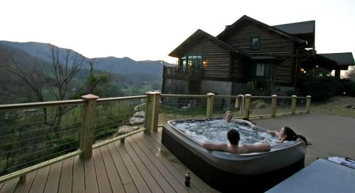 two people in a hot tub on a deck at Deluxe Bed and Breakfast Getaway in the Great Smoky Mountains near Leicester, North Carolina in Newfound