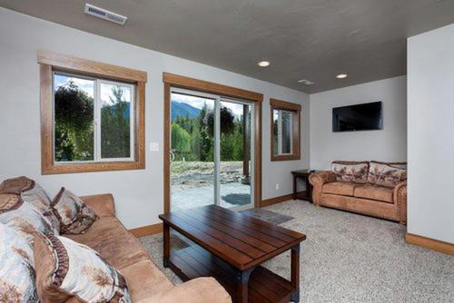 a living room with a couch and a coffee table at Sunny Mountain Cabin for a Group Getaway in West Glacier, Montana in West Glacier