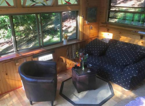 una sala de estar con un sofá y una mesa en Rustic Off-Grid Cabin Getaway near Wayne National Forest, Ohio, en Athens