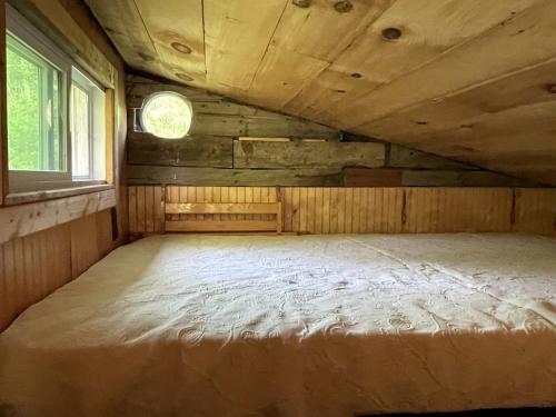 un letto grande in una stanza con una finestra di Gorgeous Tiny House Rental for a Glamping Getaway near Saratoga Springs in Upstate New York a Argyle