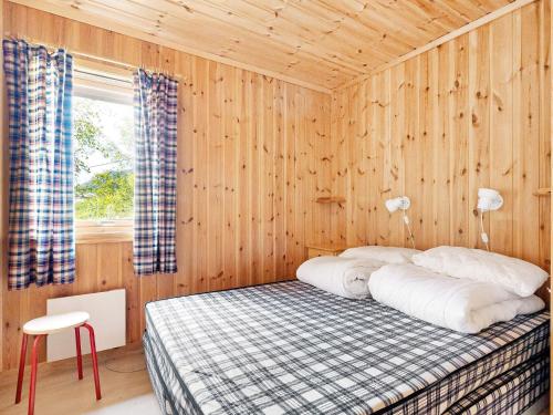 a bedroom with a bed in a wooden wall at 6 person holiday home in Ånneland in Ånneland