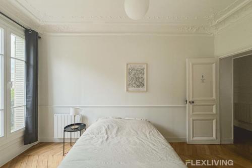 ein weißes Schlafzimmer mit einem Bett und einem Stuhl in der Unterkunft Cozy Room in Alésia Paris 14th in Paris